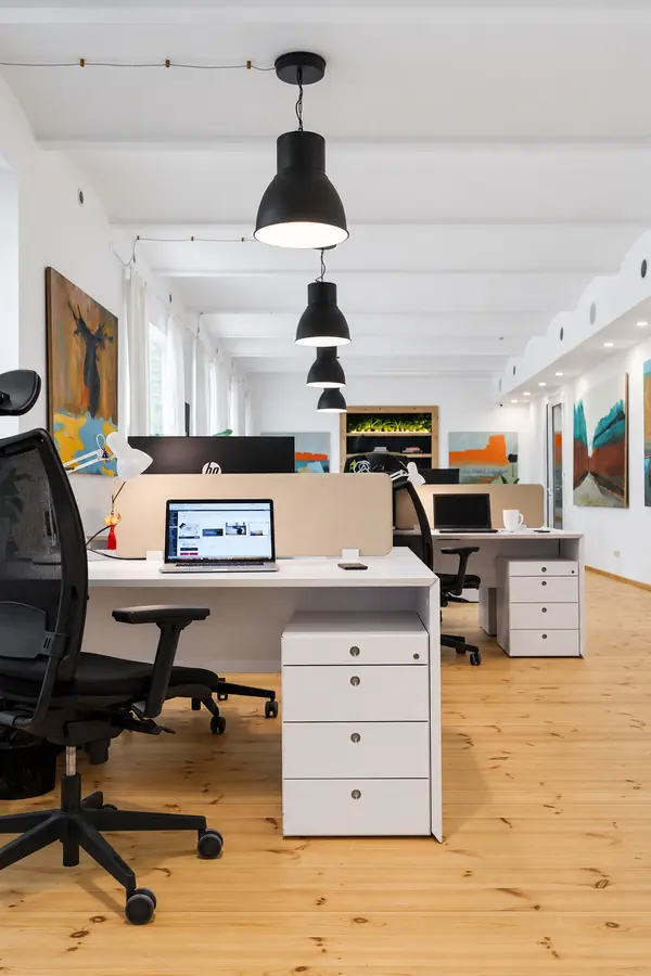 Darba vietas ar ergonomiskiem krēsliem kopstrādes telpā