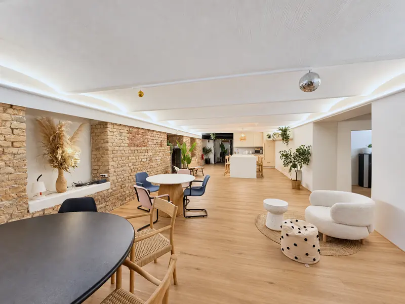 Coworking Riga telpa meistarklasēm ar galdiem un klubkrēsliem